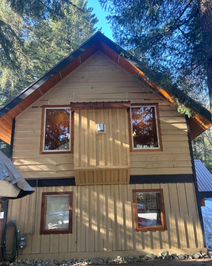 Before: Gable end elevation with upper windows and vertical siding before painting, Whistler, BC