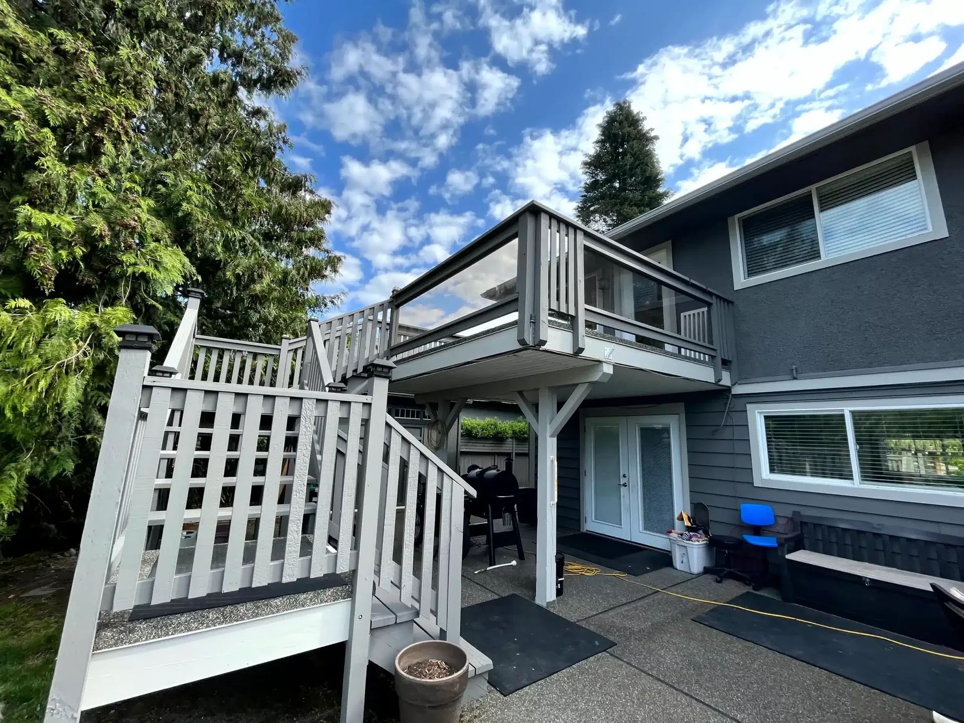 Two-story home with dark siding and white trim under blue sky