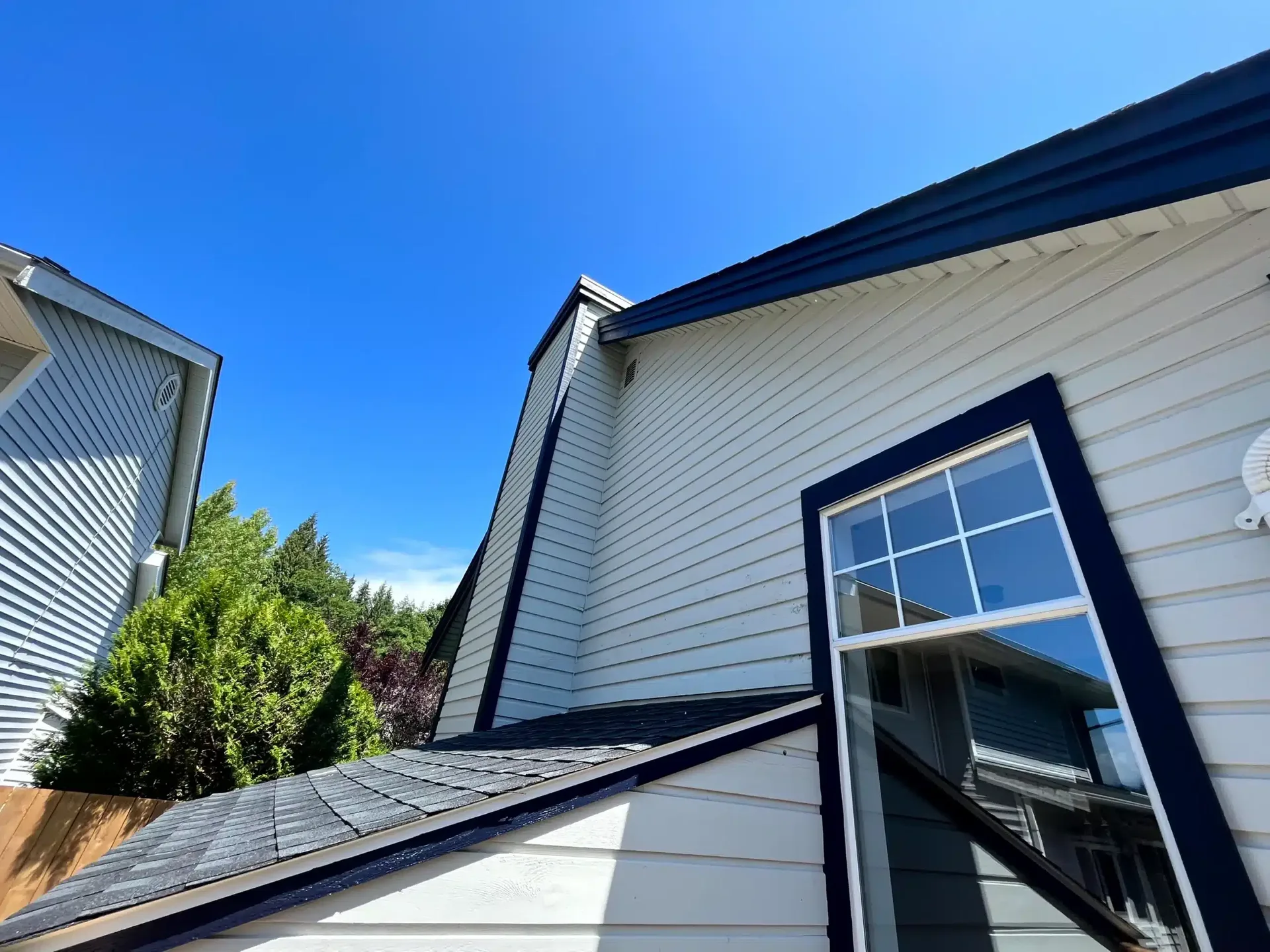 Two-story home with dark navy siding and white window trim
