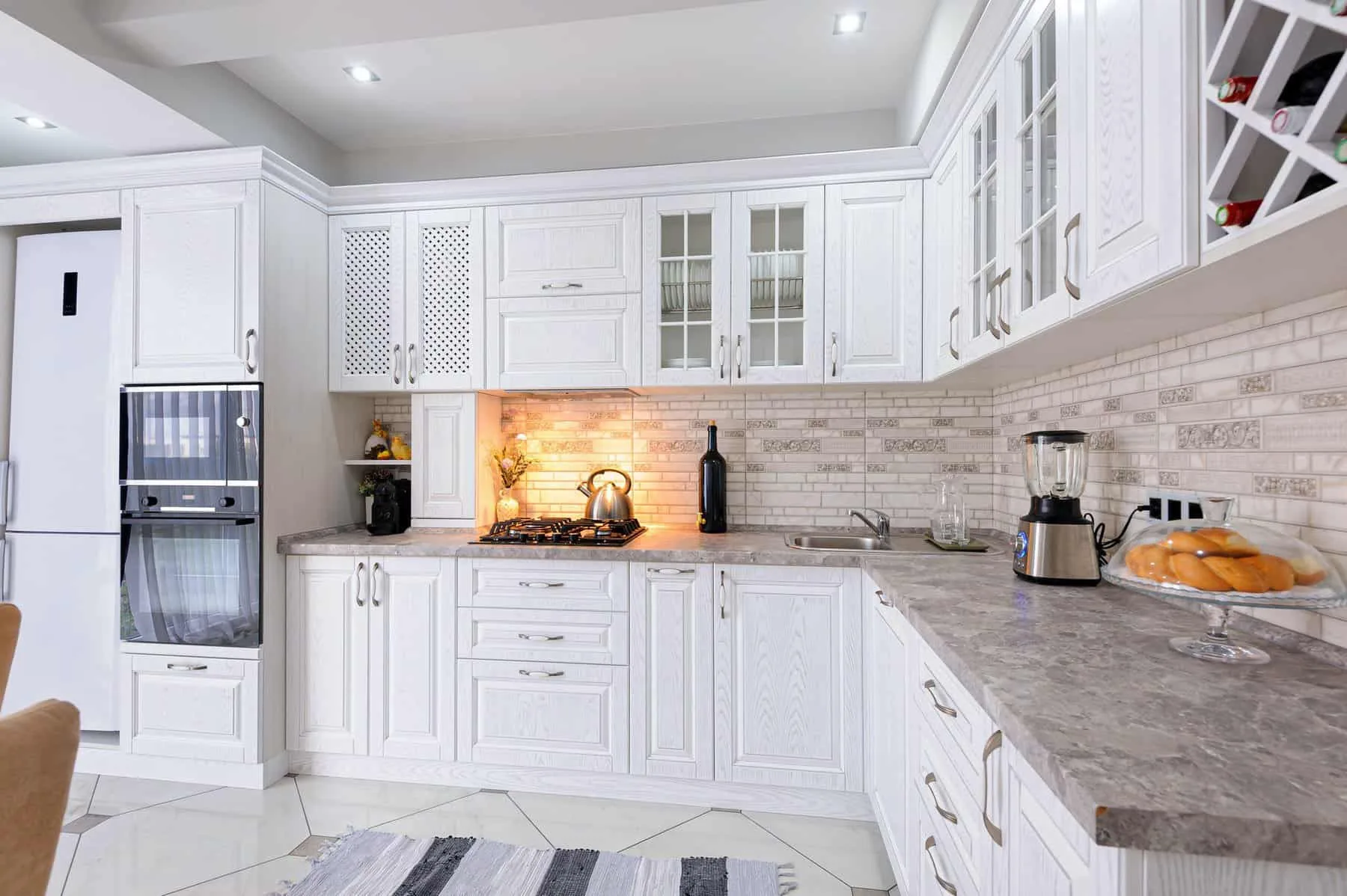 White painted cabinets with light tile backsplash