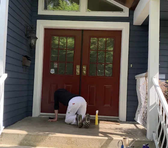 Painter finishing a bold red double front door — exterior door painting by Colour Craft Painting