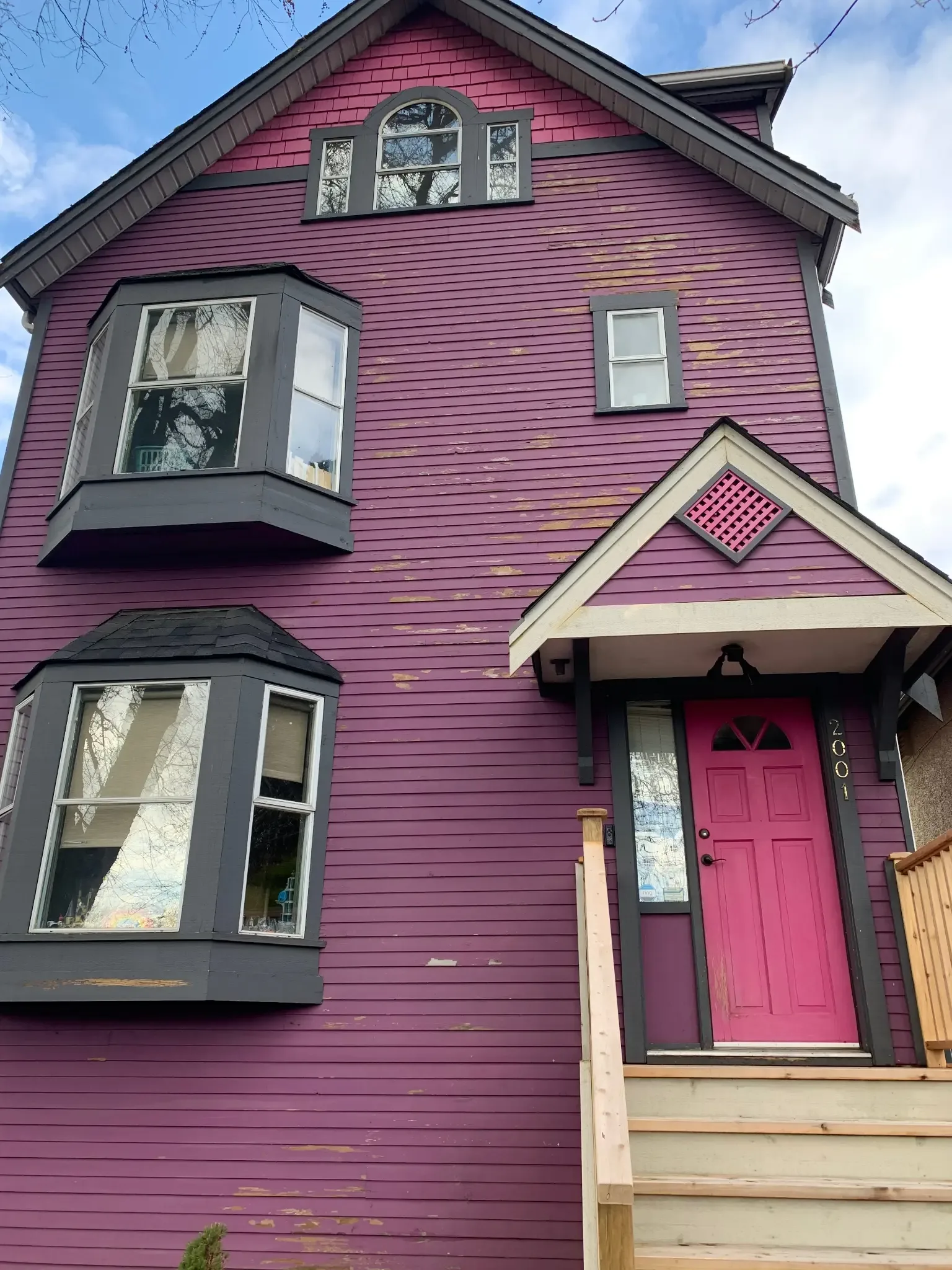 Before — Front of 3-storey East Vancouver home with peeling siding and new stairs