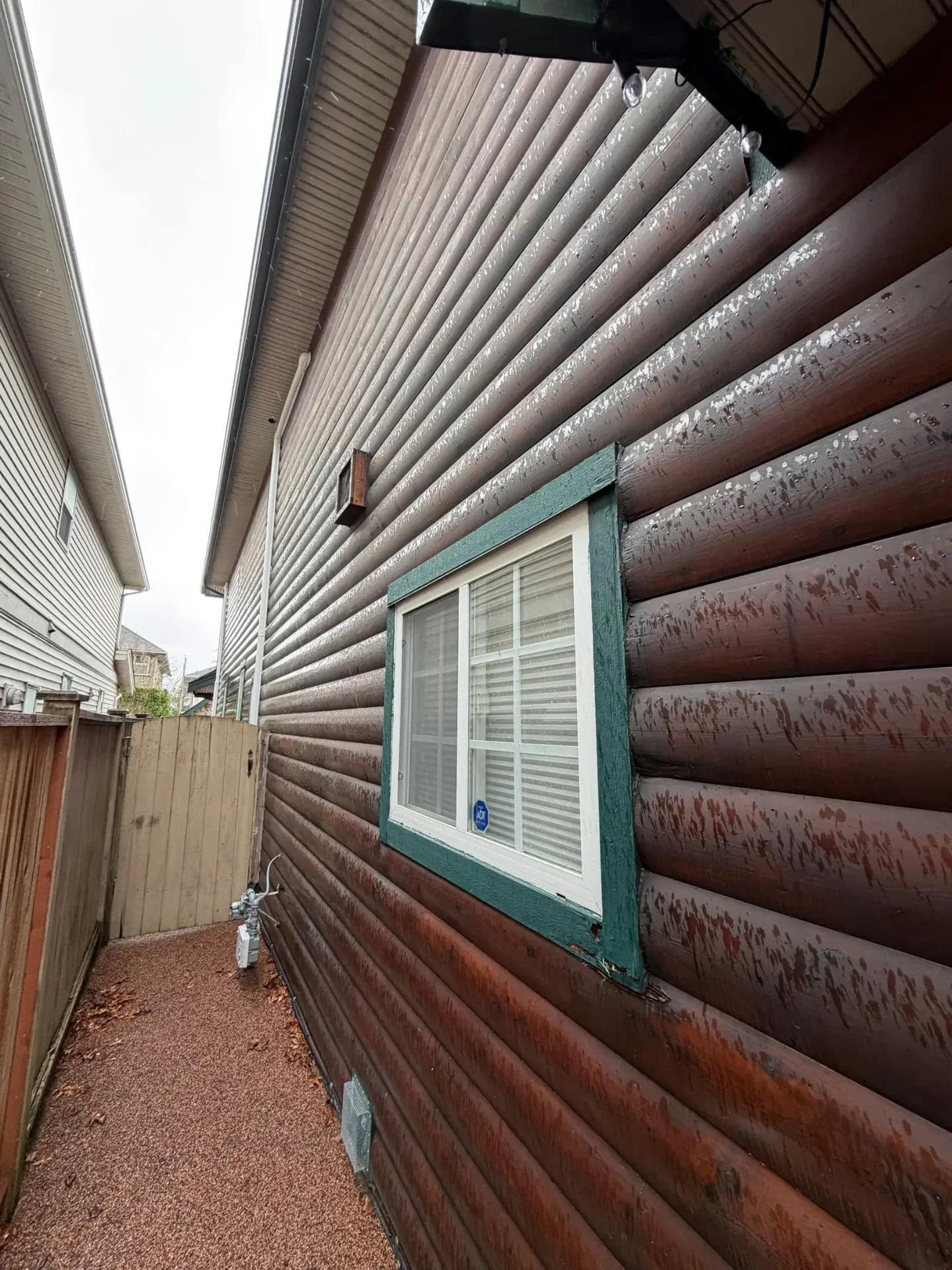 Before exterior detail of weathered log siding and window trim in Steveston Richmond BC