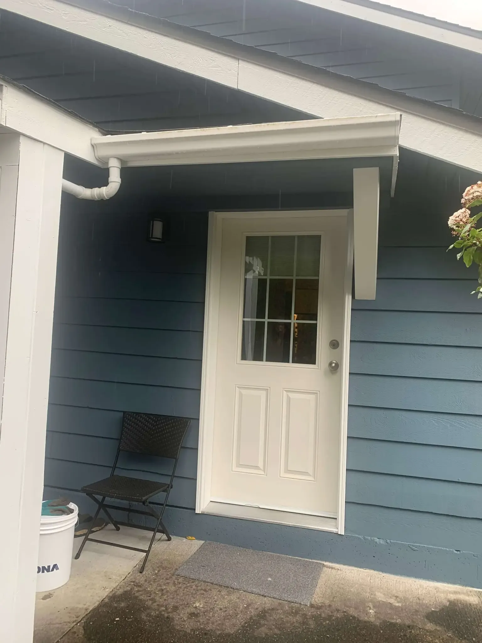 After — Yves residence back entry, steel blue siding with white door, Garibaldi Highlands Squamish BC
